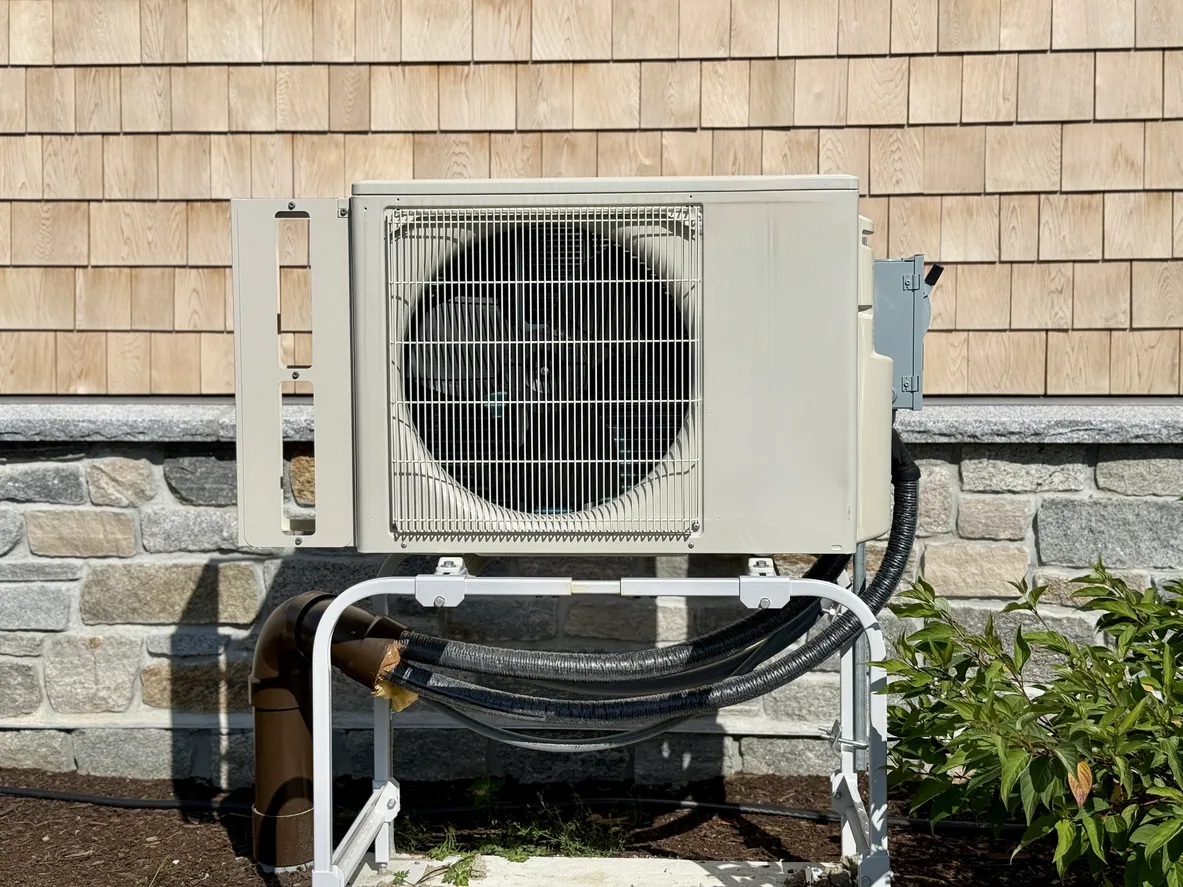 Close-up of building exterior with air heat pump.