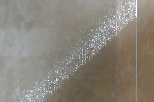 Hard water visible residue on a glass shower.
