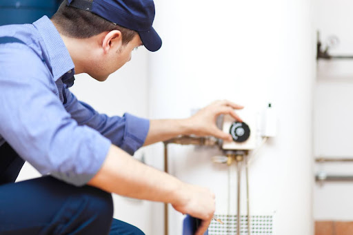 a technician repairs a tank water heater
