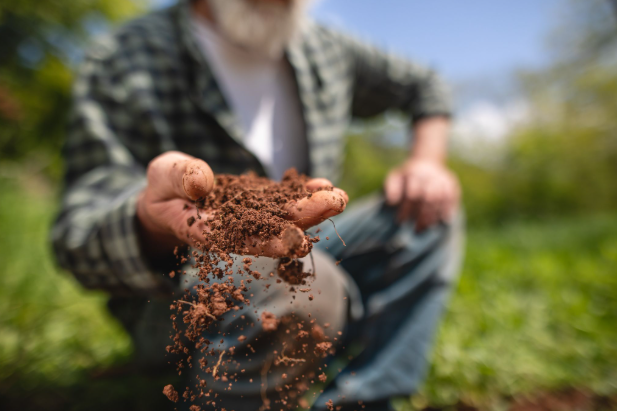 A close up picture of a man showing soil