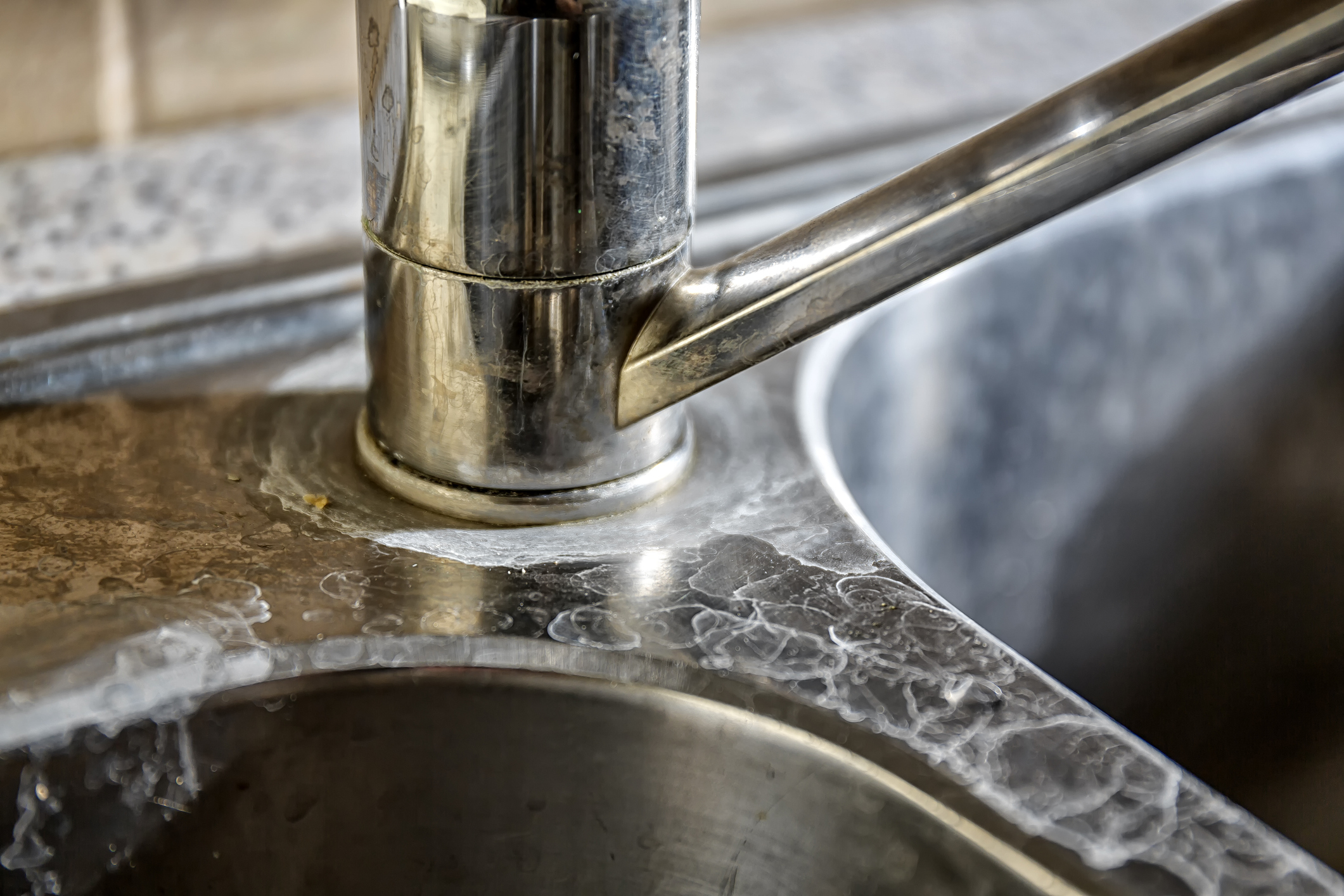 Hard water buildup visible on a stainless steel sink