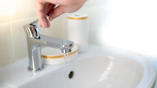 Adjusting water pressure in sink.